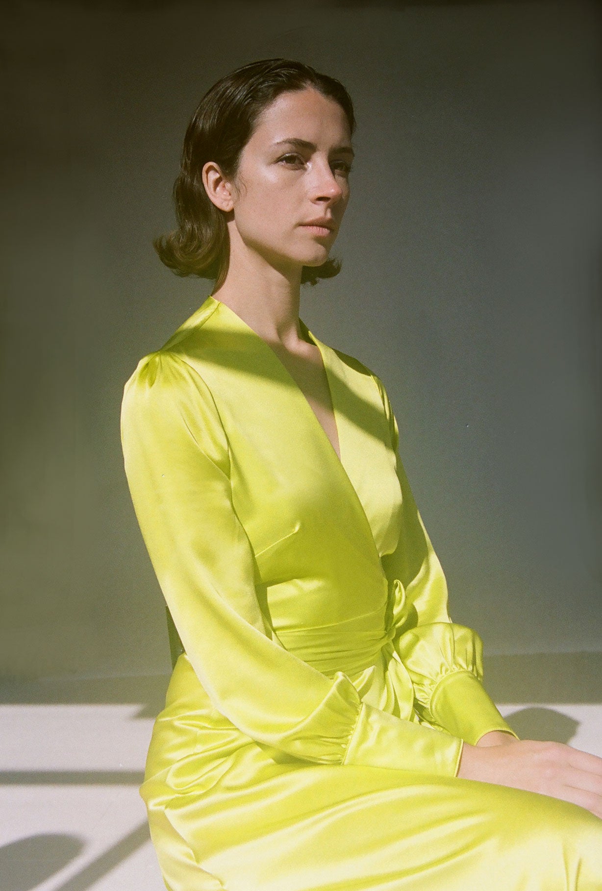 Editorial image of the chartreuse satin silk charmeuse Kamperett Adelaide Midi Dress.