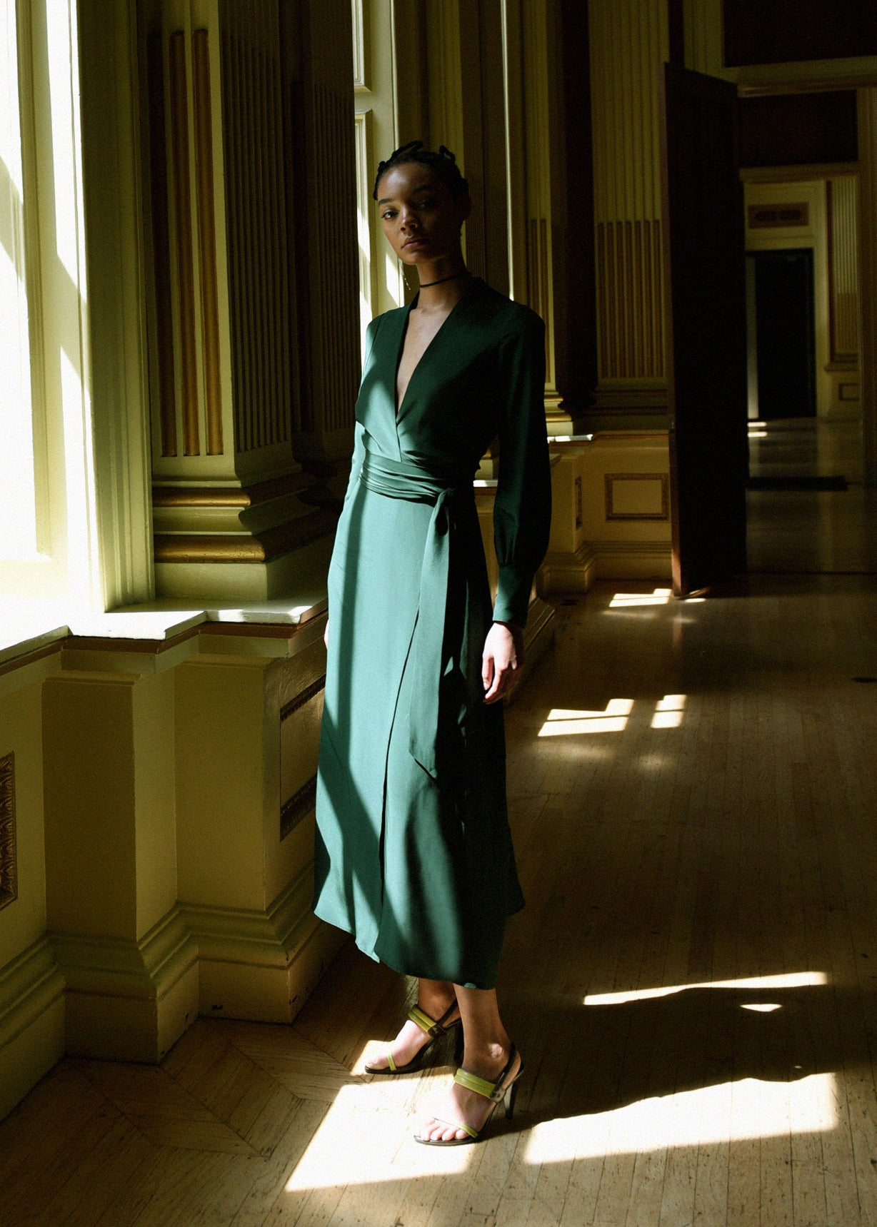 Angled view of the dark green matte silk charmeuse Kamperett Adelaide Midi Dress showing the wrap closure.