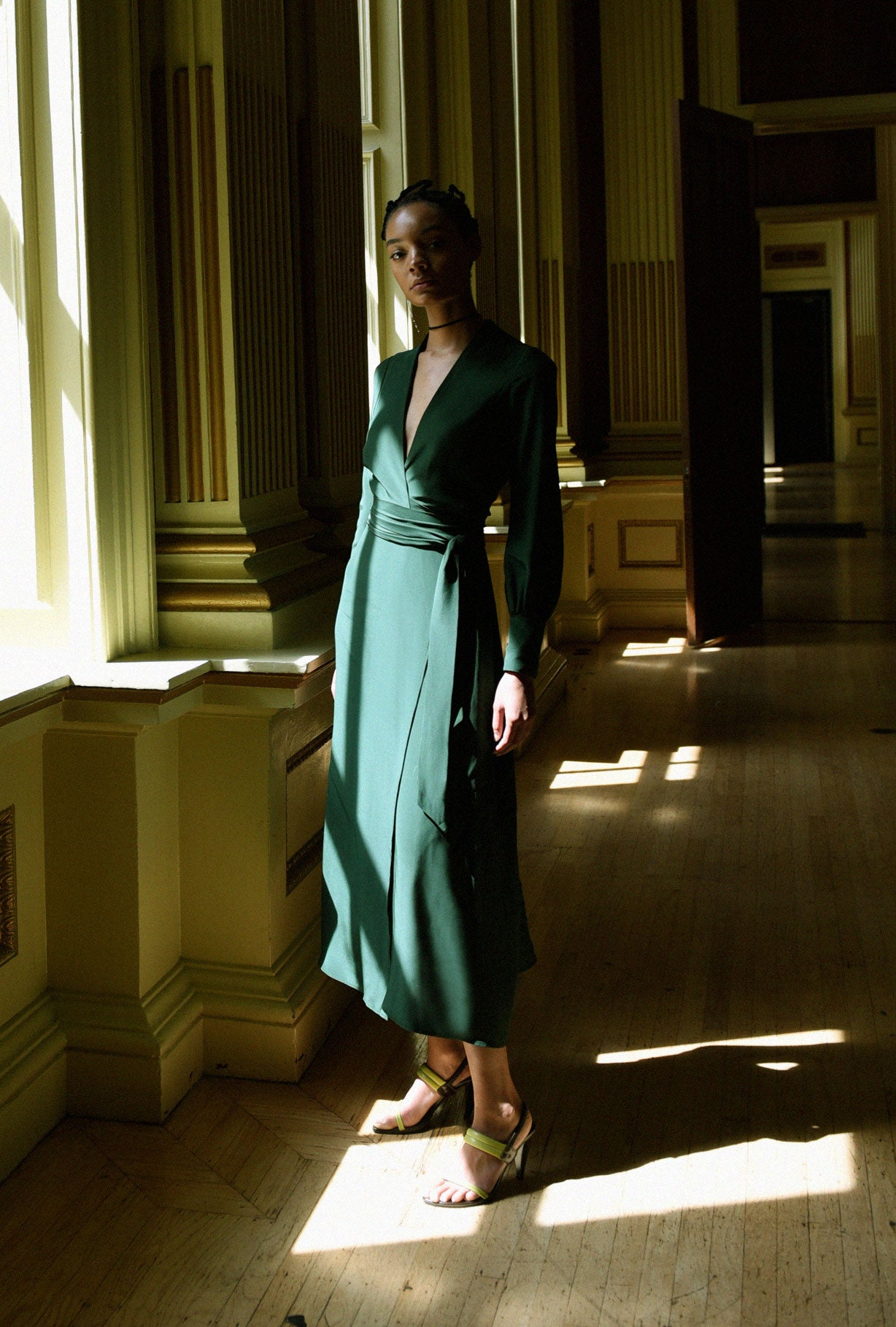 Angled view of the dark green matte silk charmeuse Kamperett Adelaide Midi Dress showing the wrap closure.