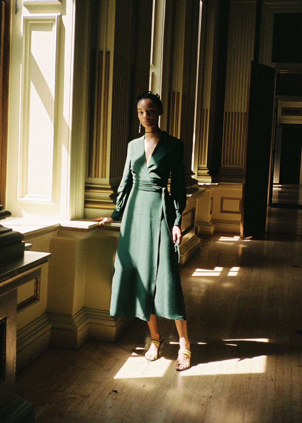 Front view of a model wearing the dark green matte silk charmeuse Kamperett Adelaide Midi Dress, a wrap dress with plunging neckline and full sleeves.