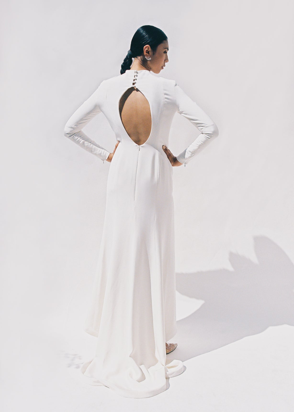 Full-length view of the Kamperett Arc Gown in Ivory silk crepe, featuring a minimalist mock neck, long tapered sleeves, and a sculptural side leg slit.