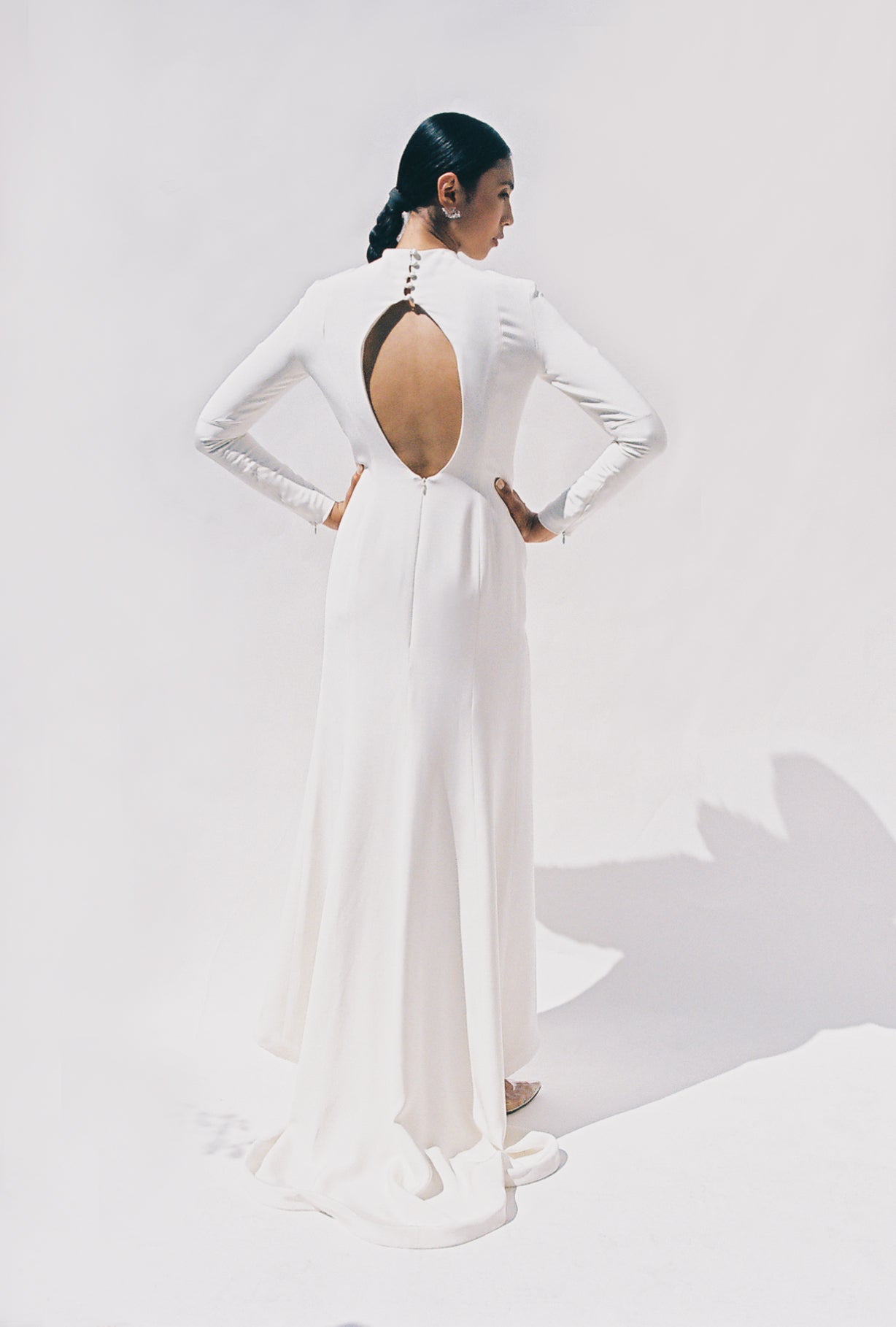 Full-length view of the Kamperett Arc Gown in Ivory silk crepe, featuring a minimalist mock neck, long tapered sleeves, and a sculptural side leg slit.