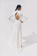 Full-length view of the Kamperett Arc Gown in Ivory silk crepe, featuring a minimalist mock neck, long tapered sleeves, and a sculptural side leg slit.