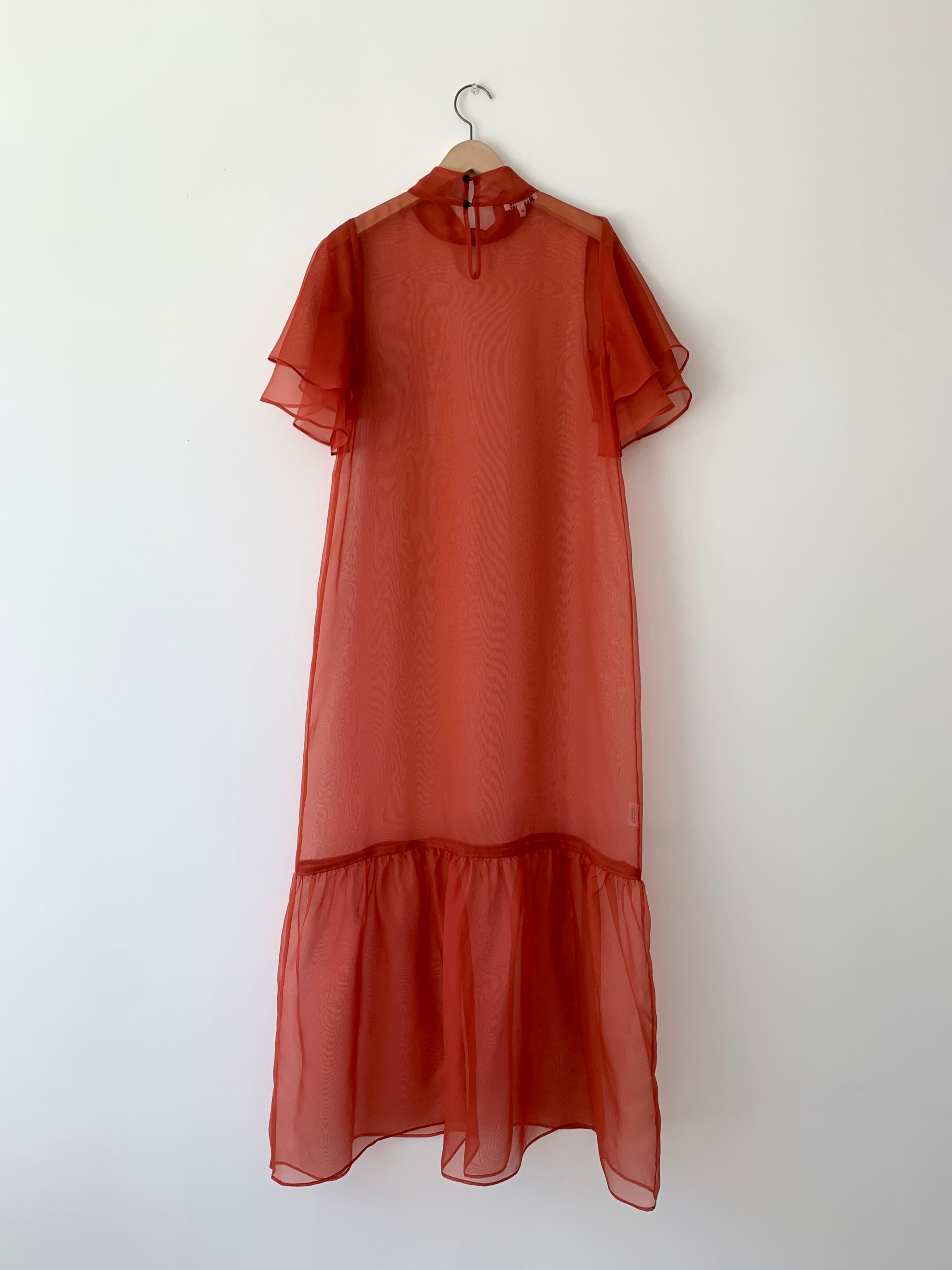 Back view of the rust silk organza Kamperett Barre Dress with grosgrain button closure at center back.