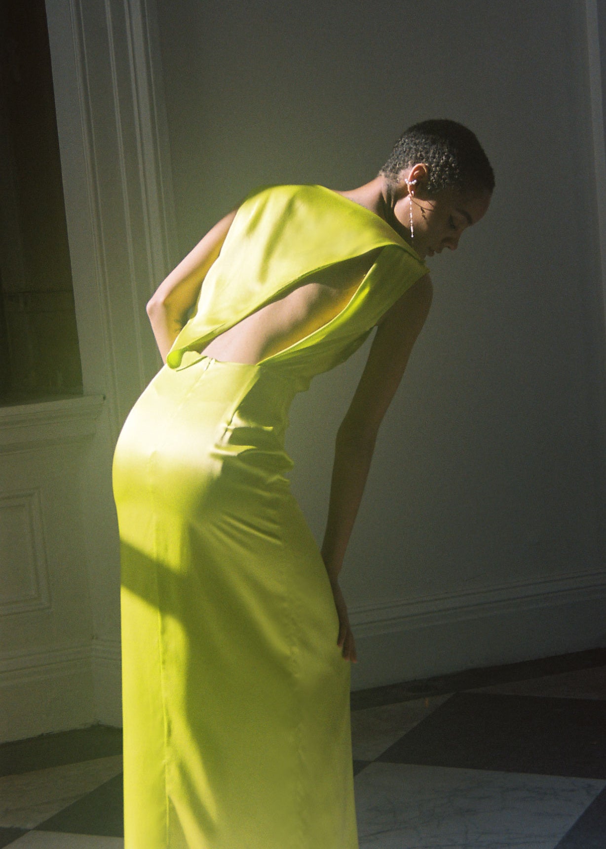 Angled view of the chartreuse silk charmeuse Kamperett Lockwood Gown showing the sleeveless bodice.