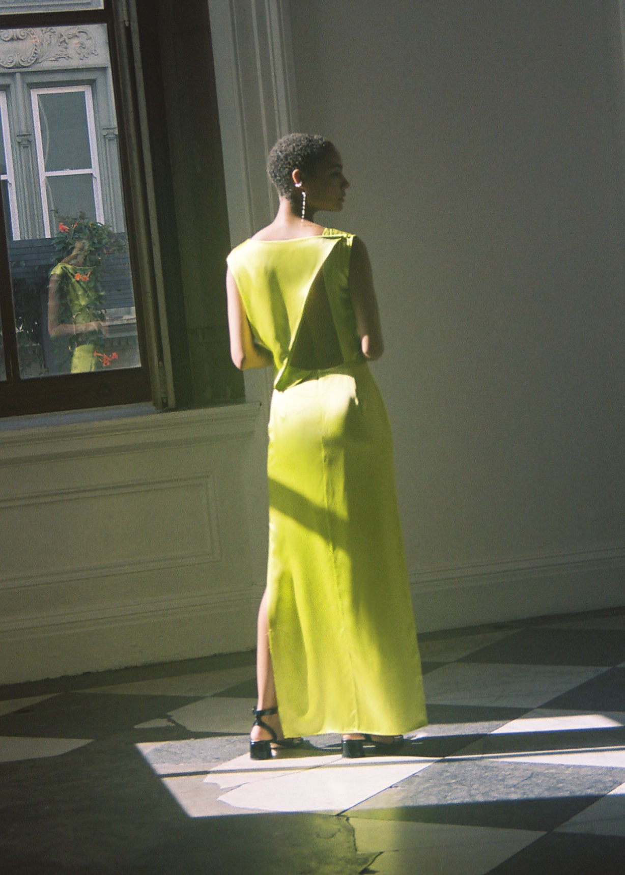Back view of the chartreuse silk charmeuse Kamperett Lockwood Gown with dramatic asymmetrical back cut-out.