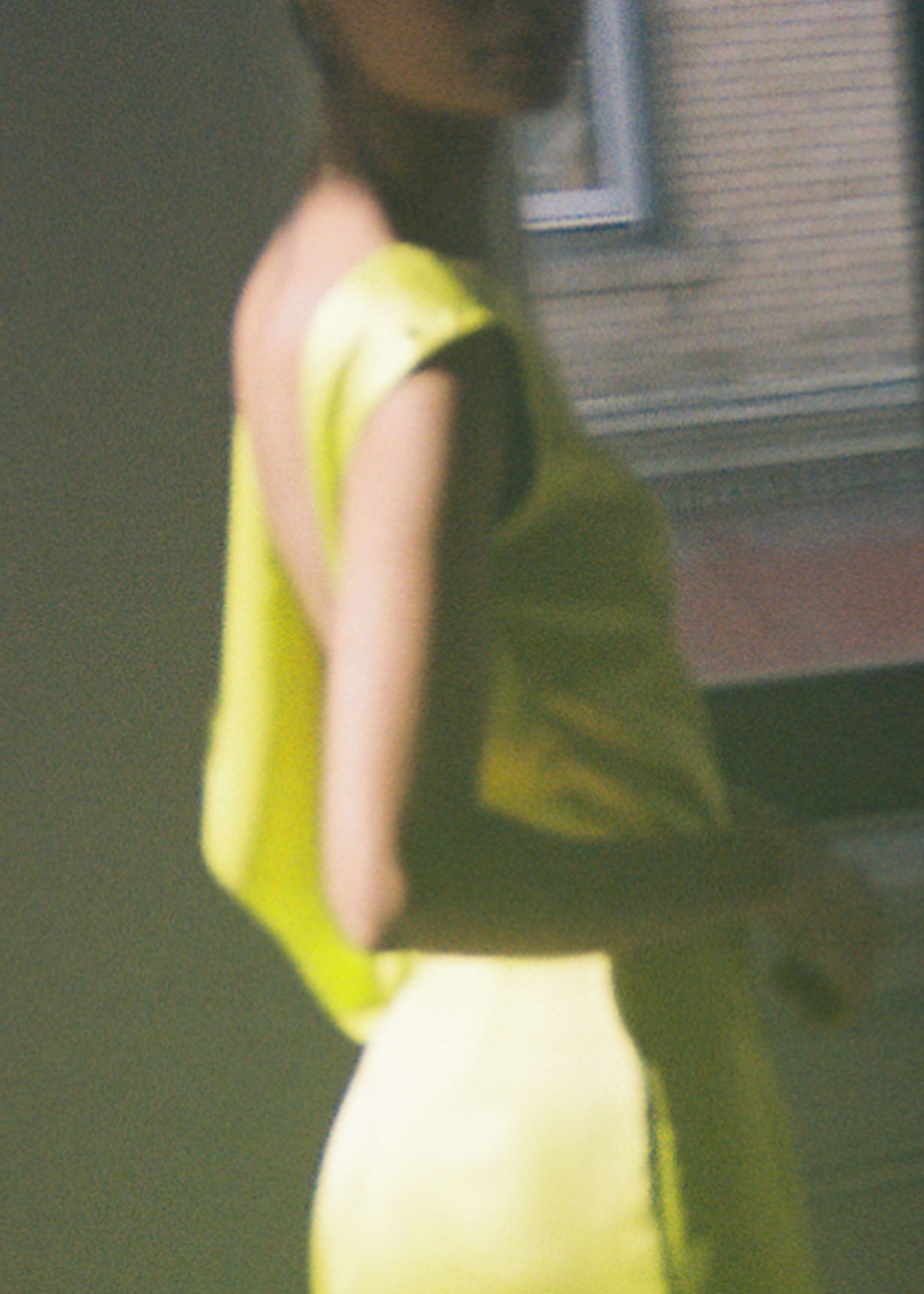 Side view of the chartreuse silk charmeuse Kamperett Lockwood Gown showing the deep side slit.
