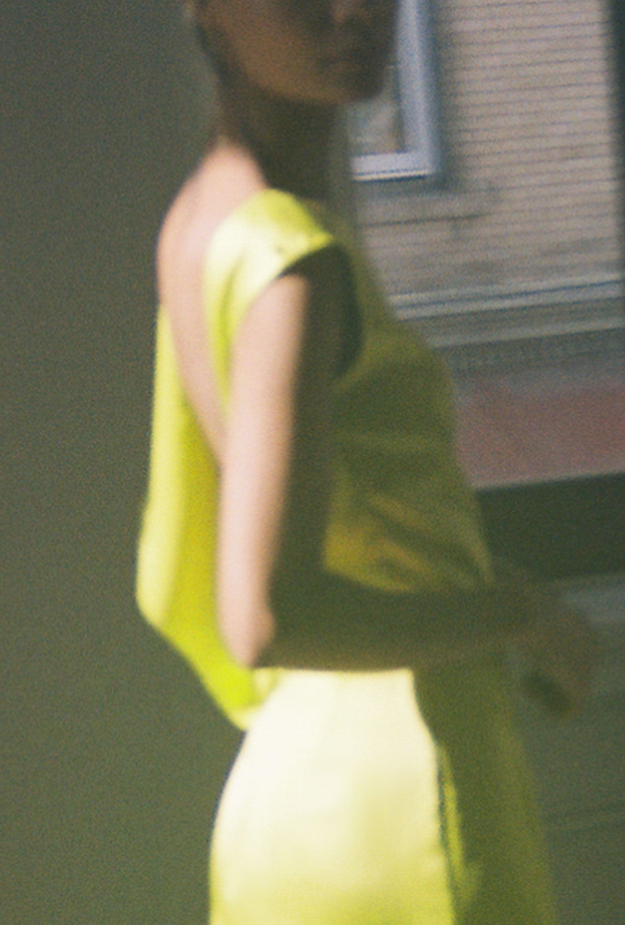 Side view of the chartreuse silk charmeuse Kamperett Lockwood Gown showing the deep side slit.