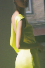 Side view of the chartreuse silk charmeuse Kamperett Lockwood Gown showing the deep side slit.