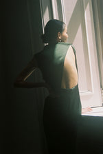 Back view of the dark green silk charmeuse Kamperett Lockwood Gown with dramatic asymmetrical back cut-out.