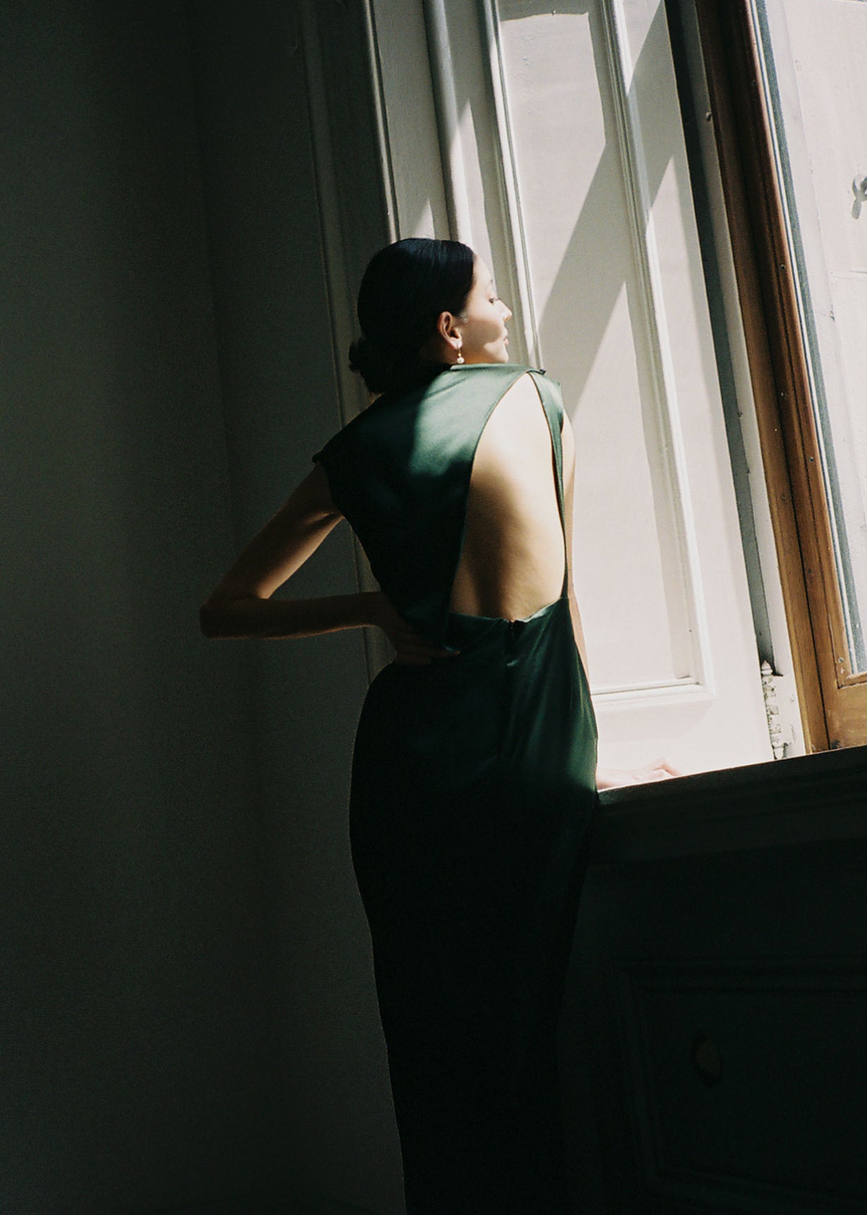 Front view of a model wearing the dark green silk charmeuse Kamperett Lockwood Gown, a sleeveless floor-length column.