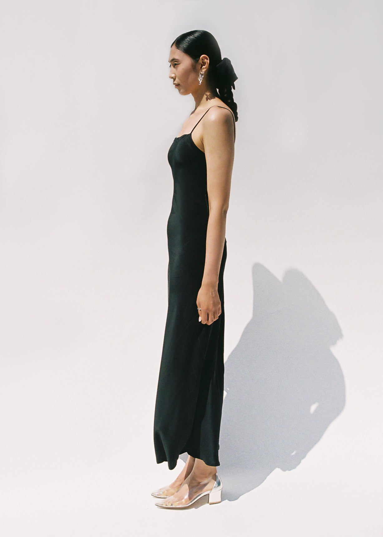 Side view of the black matte silk charmeuse Kamperett Long Slip showing the bias-cut drape.