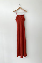 Front view of the rust matte silk charmeuse Kamperett Long Slip, a bias-cut maxi with straight neckline.