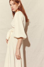 Side view of the alabaster four-ply silk crepe Kamperett Loretta Gown showing the full skirt and wrap closure.