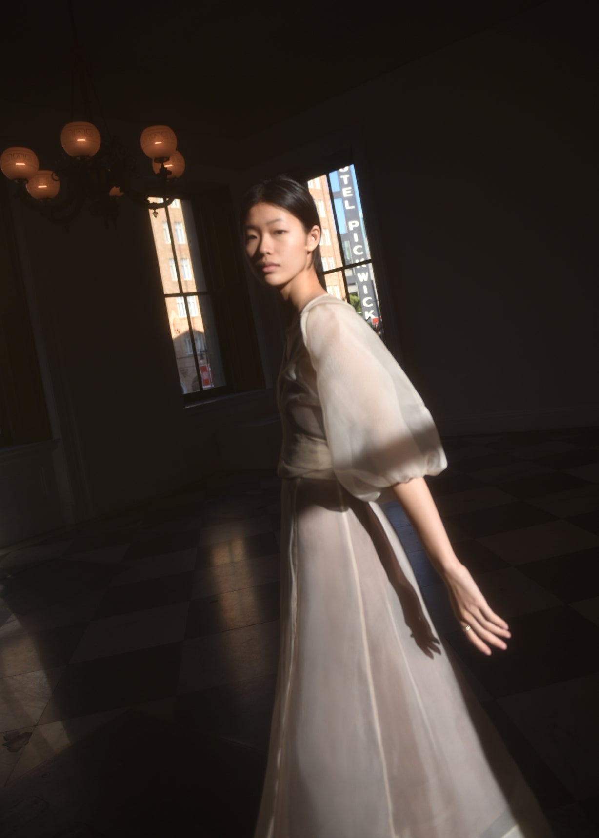 Front view of a bride wearing the ivory silk organza Kamperett Loretta Midi wedding dress, a wrap with elbow-length sleeves and shoulder ruffle.