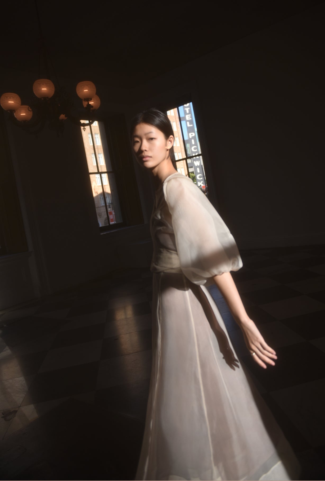 Front view of a bride wearing the ivory silk organza Kamperett Loretta Midi wedding dress, a wrap with elbow-length sleeves and shoulder ruffle.