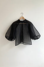 Editorial image of the black silk organza Kamperett Meiere Blouse with cut-glass-inspired architectural sleeves.