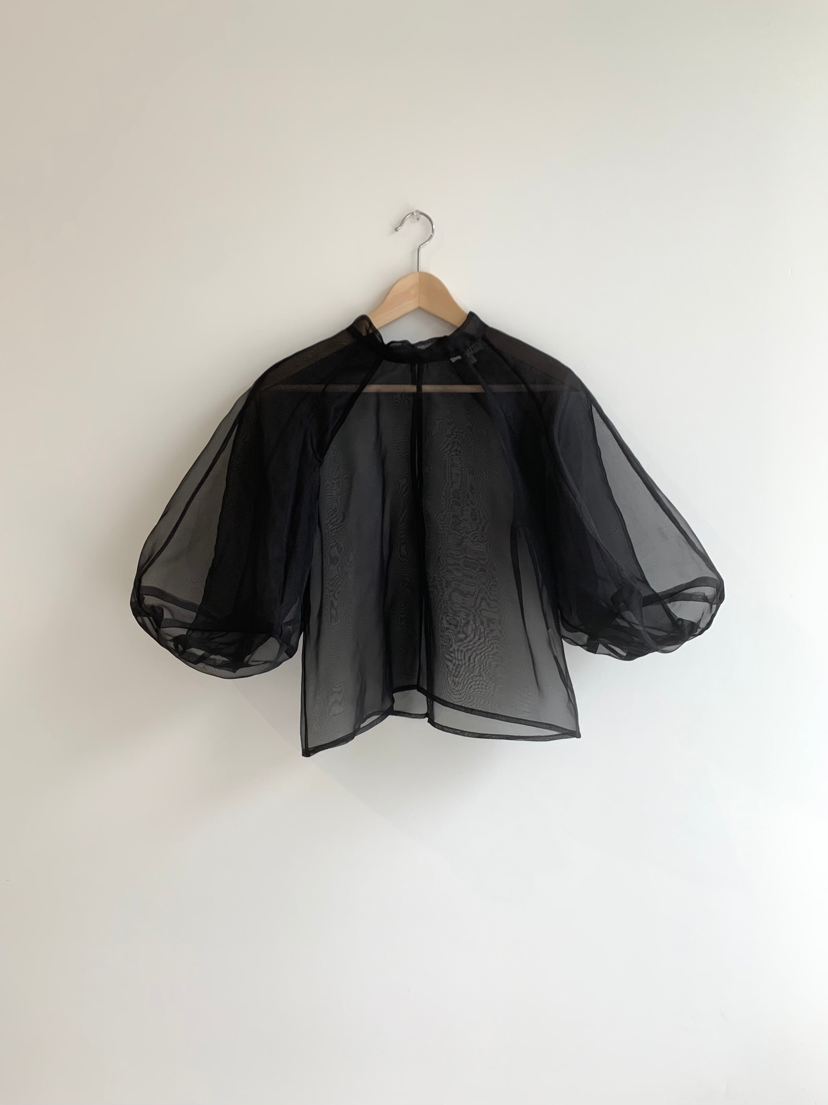 Editorial image of the black silk organza Kamperett Meiere Blouse with cut-glass-inspired architectural sleeves.