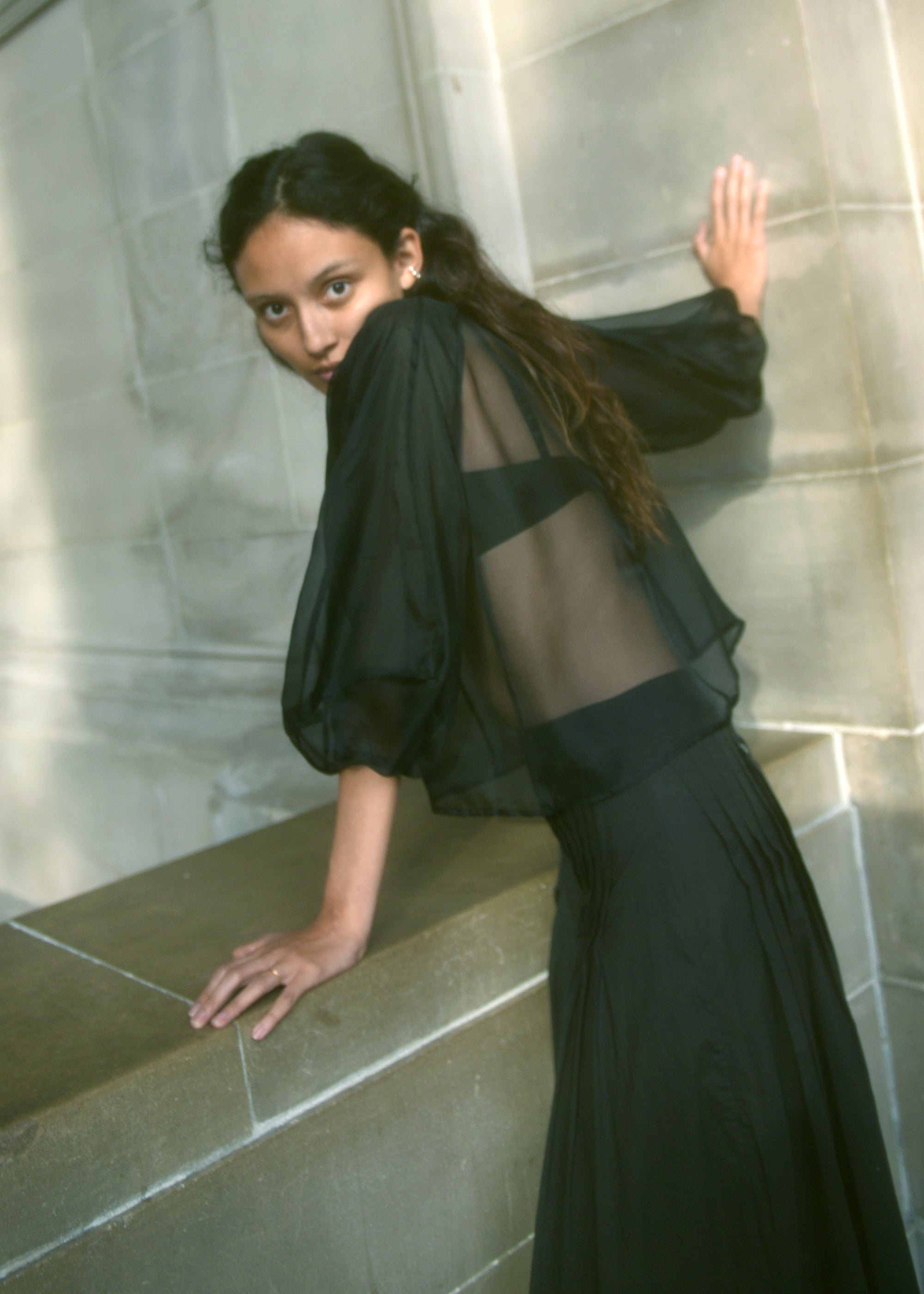 Side view of the black silk organza Kamperett Meiere Blouse showing the intricately seamed sleeves.