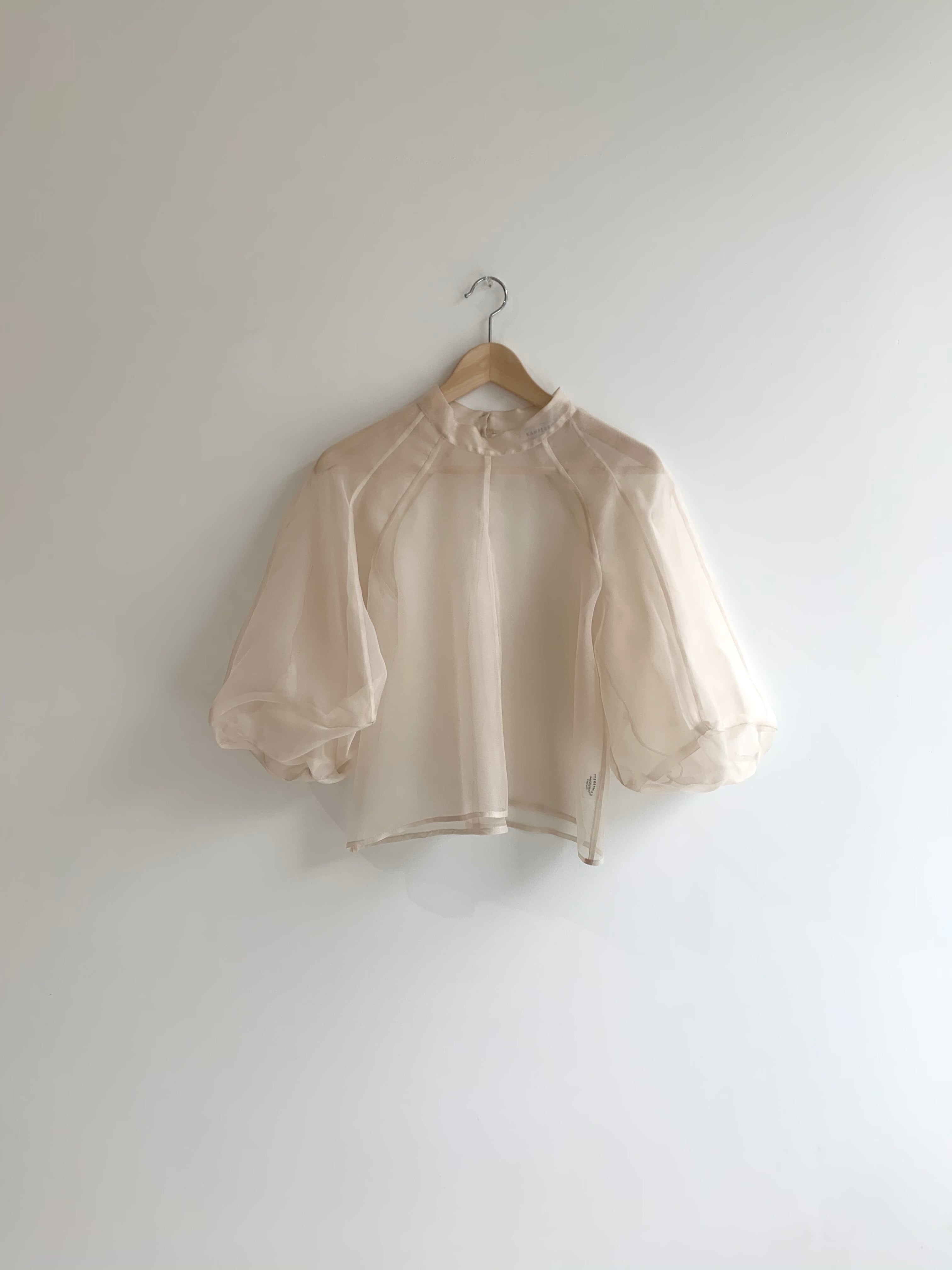 Front view of a bride wearing the ivory silk organza Kamperett Meiere Blouse with architectural sleeves and mock neck.
