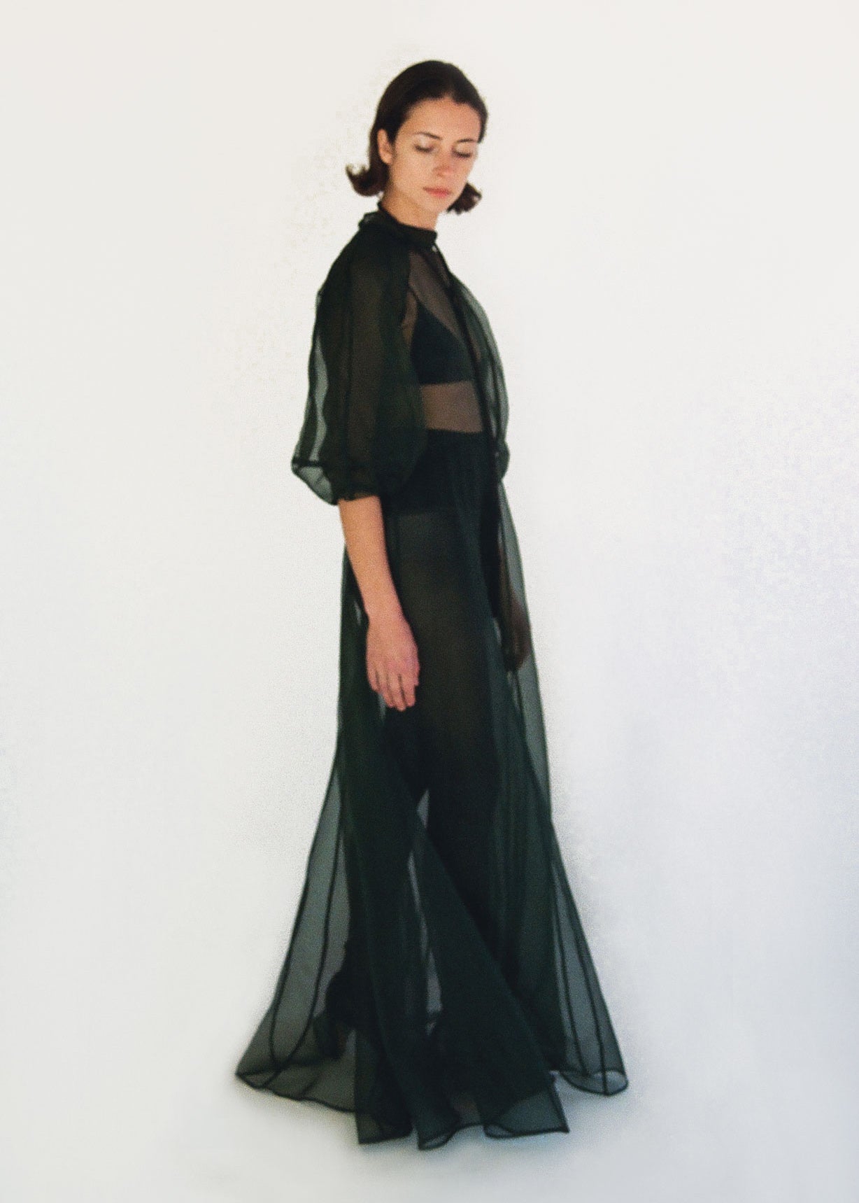Back view of the dark green silk organza Kamperett Meiere Gown with mock neck and back button closure.