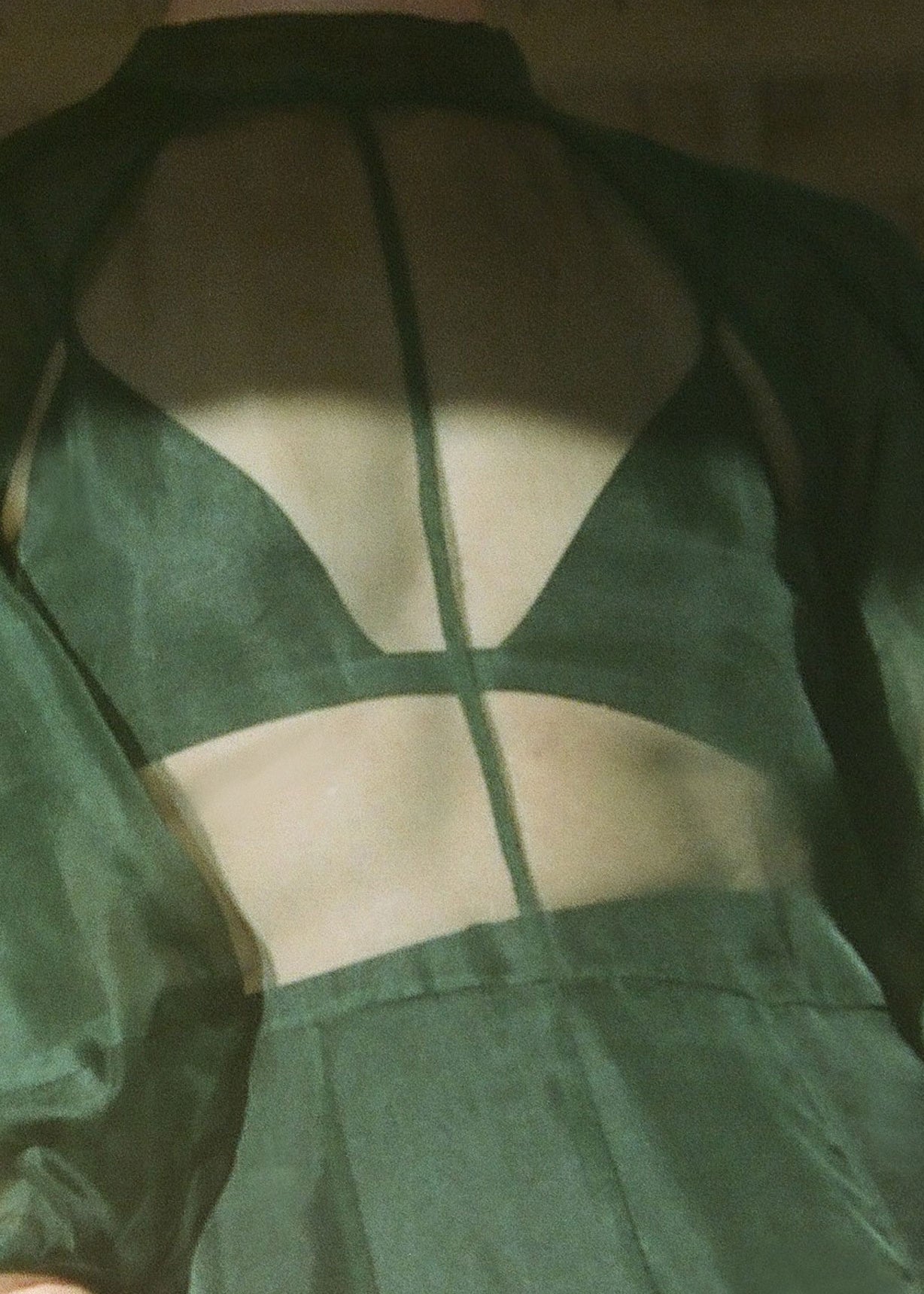 Motion shot of the dark green silk organza Kamperett Meiere Gown, capturing the sweeping multi-godet skirt.