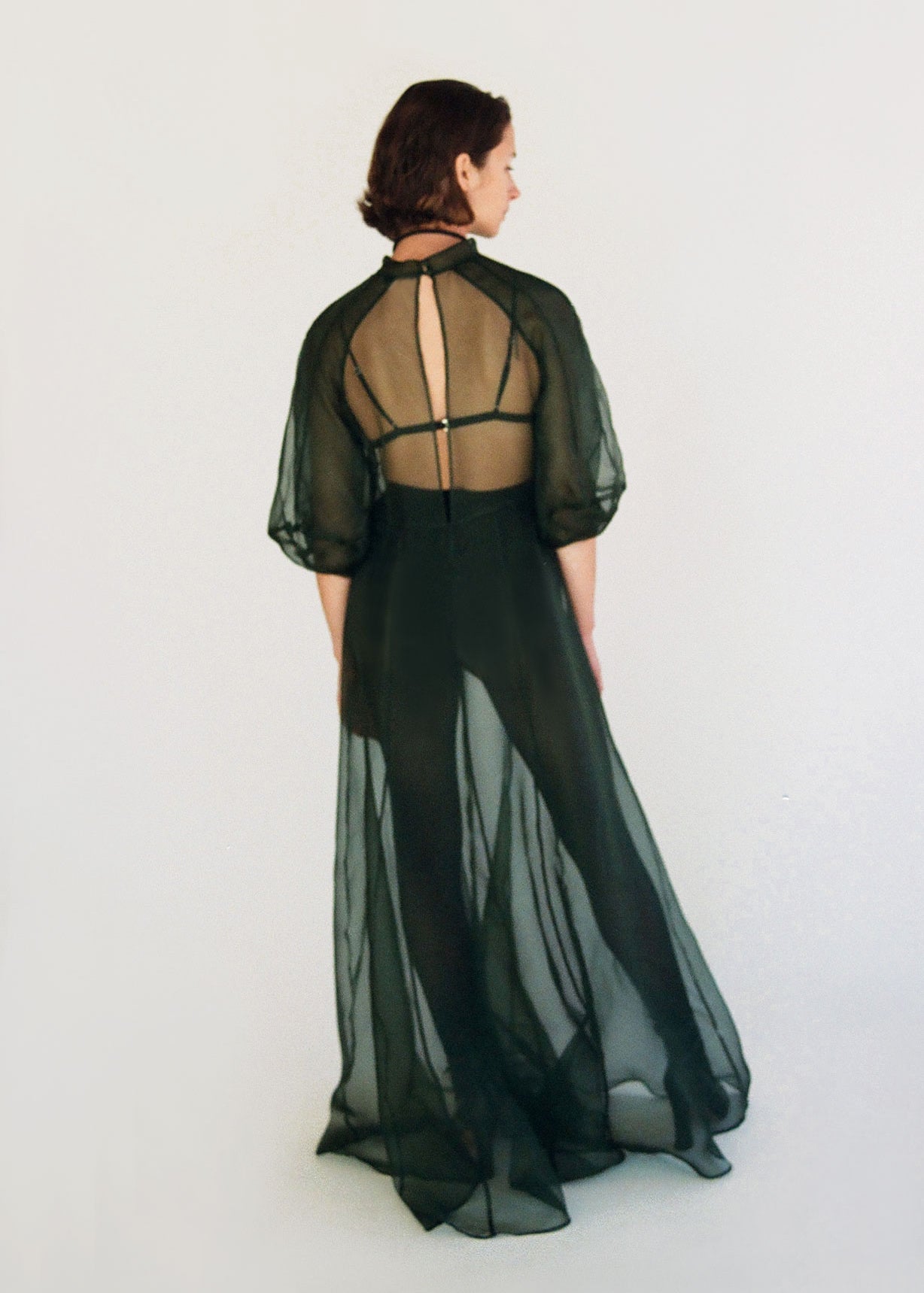 Side view of the dark green silk organza Kamperett Meiere Gown showing the multi-godet skirt opening into fullness.
