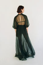 Side view of the dark green silk organza Kamperett Meiere Gown showing the multi-godet skirt opening into fullness.