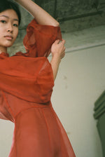 Editorial film image of the rust silk organza Kamperett Meiere Gown showing the sweeping skirt.
