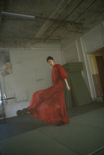 Side view of the rust silk organza Kamperett Meiere Gown with intricately seamed cut-glass sleeves.