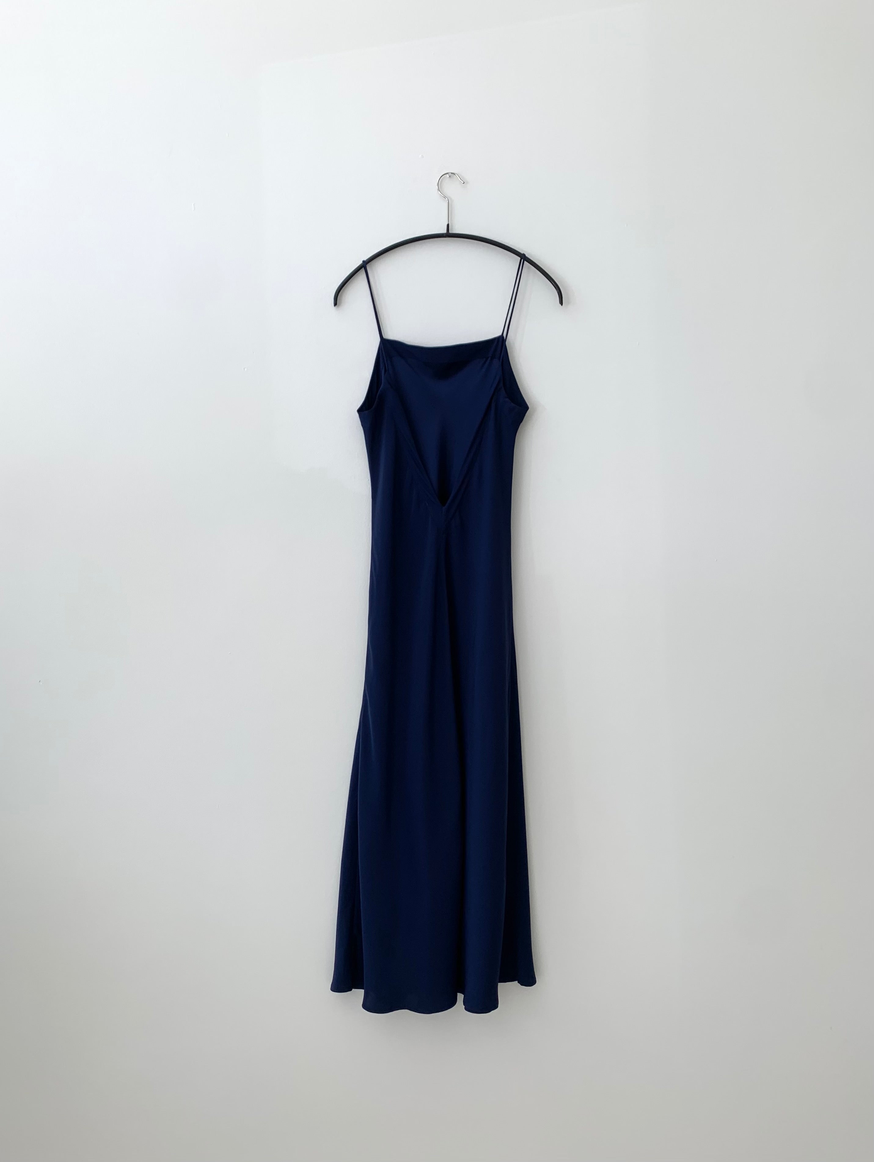 Back view of the navy silk charmeuse Kamperett Midi Slip showing the deep V back.