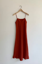 Front view of the rust sueded silk charmeuse Kamperett Midi Slip, a bias-cut mid-calf slip with straight neckline.