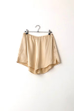 Detail view of the elastic-waist shorts on the champagne silk charmeuse Kamperett Sleep Set.
