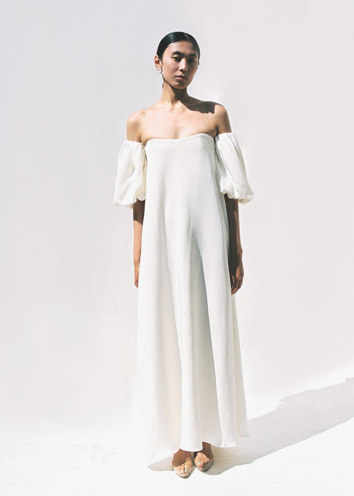 Editorial portrait of a bride in the alabaster silk crepe Kamperett Verona Gown.