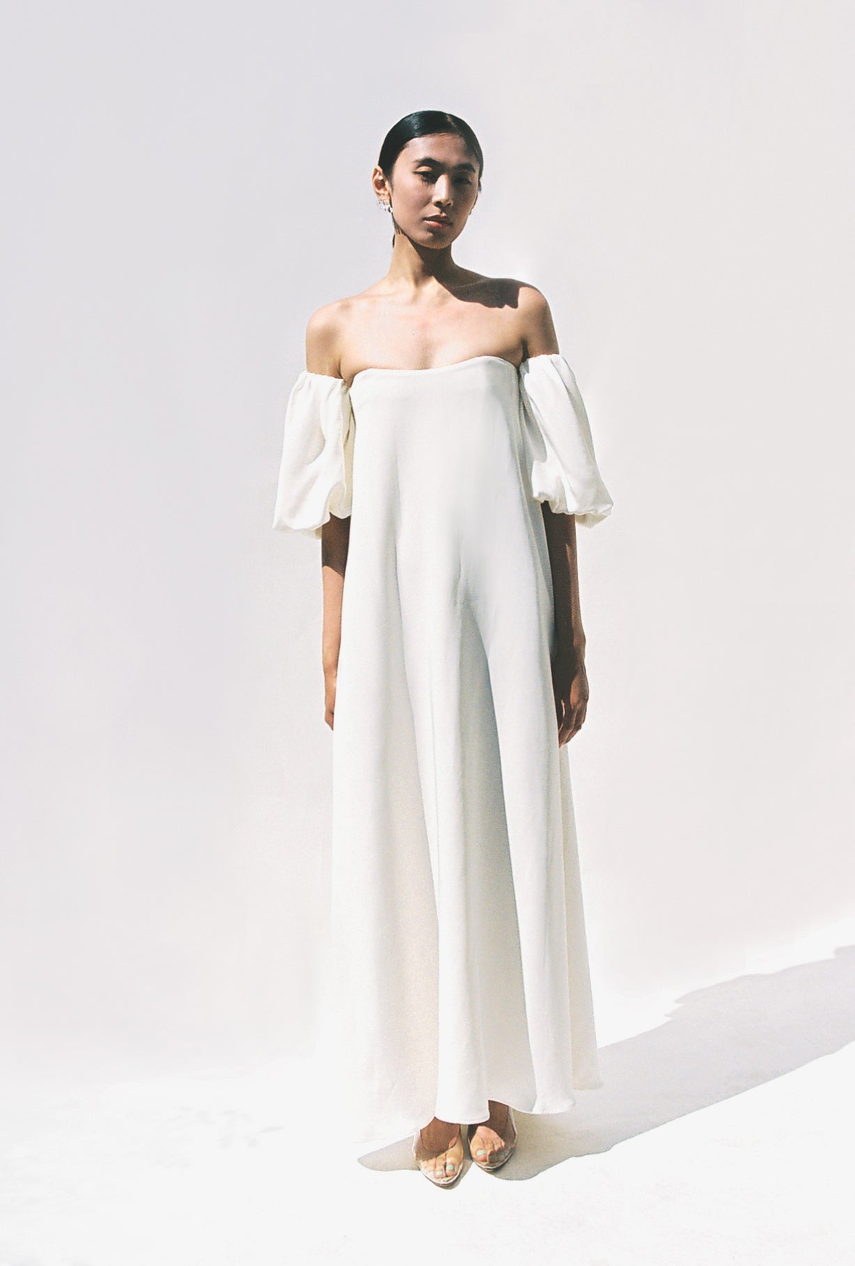 Editorial portrait of a bride in the alabaster silk crepe Kamperett Verona Gown.