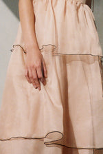 Back view of the blush silk organza Kamperett Laurence Midi Dress with corded straps tied at the shoulders.